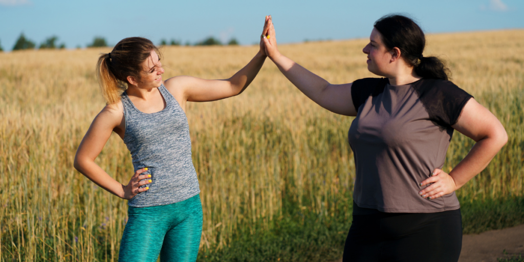 Deux femmes se tapent dans la main après une séance de sport.
