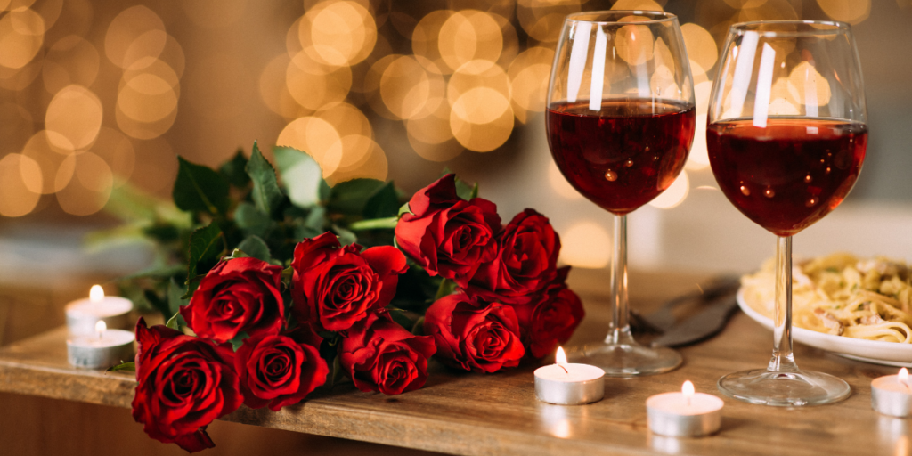 Repas romantique avec roses rouges et verre de vin